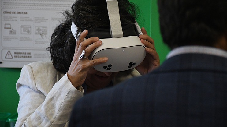 Probando la realidad virtual el día de la inauguración, junto a la ficha de uso del aula.