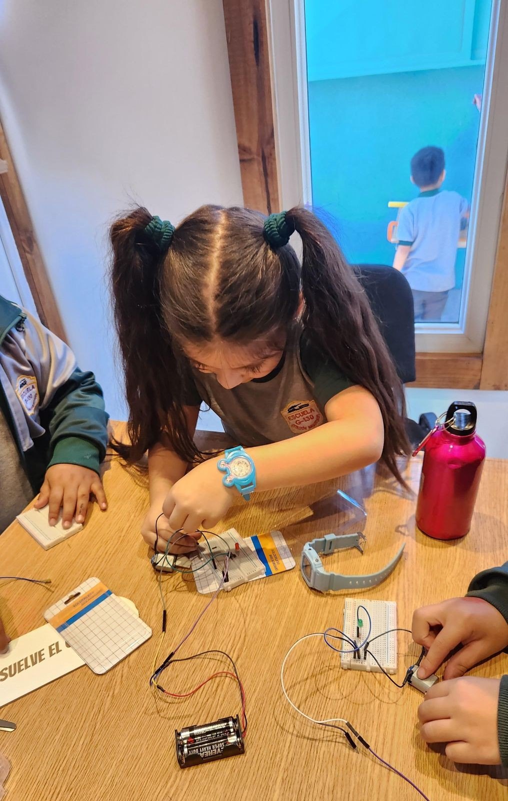 A student building a circuit in the room, in April 2024.